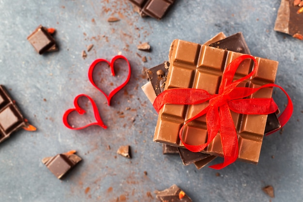 Dia dos namorados. Barras de chocolate decoradas corações e fita vermelha. Vista do topo