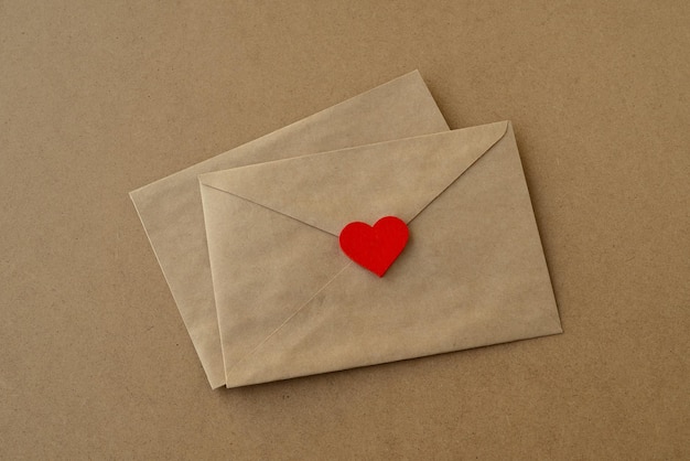 Dia dos namorados Cartas de amor, envelopes e coração vermelho em um fundo de papel kraft.