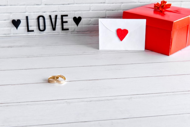 Dia dos namorados conceito anéis de ouro presente e carta de amor