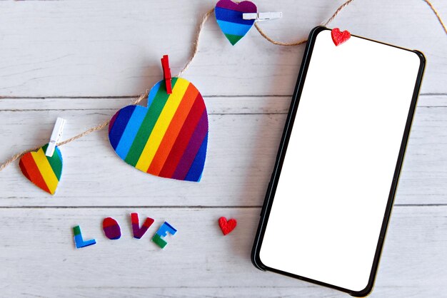 Dia dos Namorados conceito corações coloridos LGBT e telefone celular de tela branca