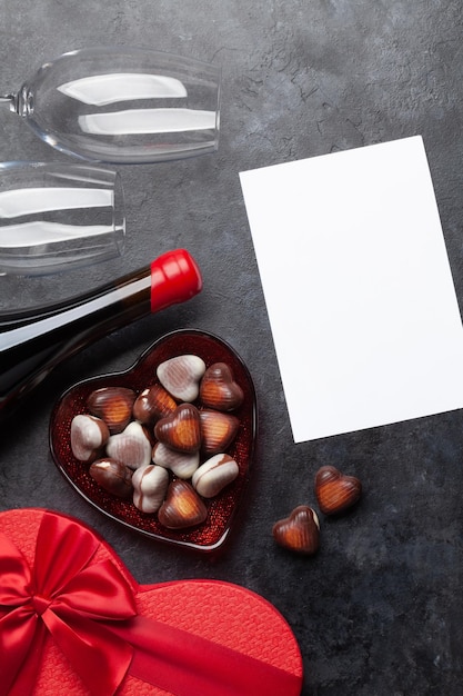 Dia dos Namorados coração caixa de presente vinho e chocolate Top vista plana deitado com cartão de saudação em branco para suas saudações