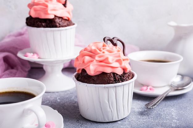 Dia dos namorados e das mães, cartão de casamento com lindo bolinho de chocolate, creme rosa e coração na superfície de pedra cinza