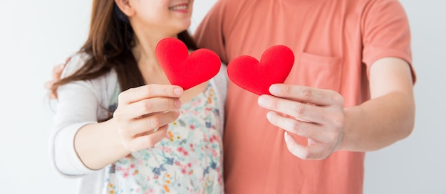 Dia dos namorados e dia mais doce, coração vermelho nas mãos de um casal apaixonado