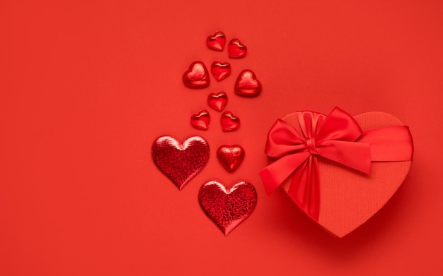 Dia dos namorados ou conceito romântico de casamento. Caixa festiva vermelha e chocolates em fundo vermelho Vista superior, configuração plana, espaço de cópia