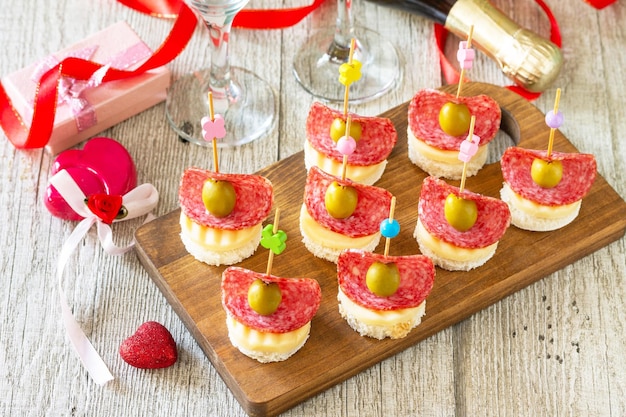 Dia dos namorados ou lanches românticos de aniversário Canapés com pão queijo salame e azeitonas