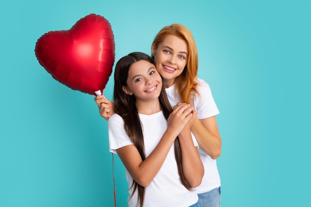 Dia dos namorados Sorridente mãe e filha segurando balão de coração de amor em fundo azul Feliz