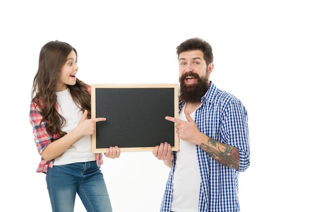 Dia dos Pais. Família feliz. pai com filha. A menina ama o pai dela. Dia da família. Menina apontando no quadro negro da escola. Pai e filha seguram o tabuleiro vazio. copie o espaço. Sorriso do pai.