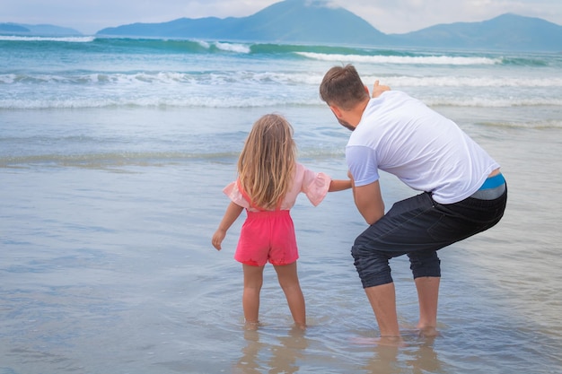 Dia dos pais. pai e filha brincando juntos ao ar livre em uma praia de verão