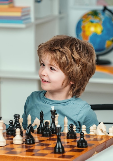 Dia dos pais, pai e filho bonitos estão jogando xadrez enquanto passam tempo juntos, relacionamento familiar