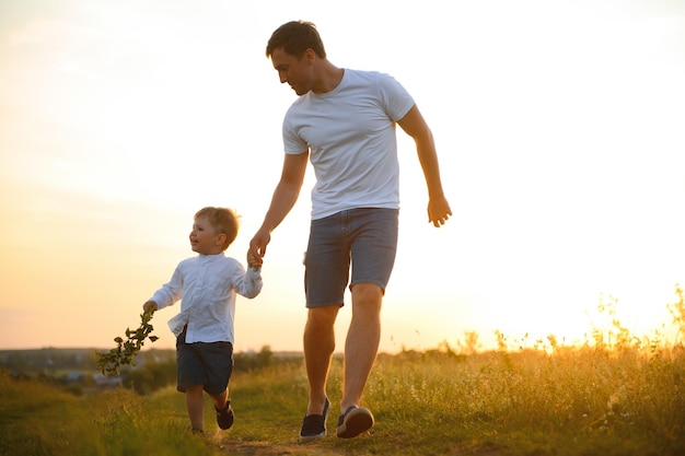 Dia dos pais Pai e filho brincando juntos ao ar livre em um verão Família feliz pai filho ao pôr do sol