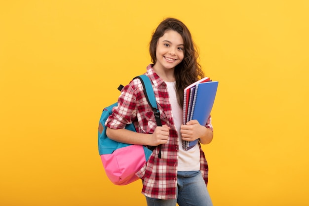 Día en la escuela secundaria colegiala con cuaderno y mochila regreso a la escuela niña adolescente lista para estudiar infancia feliz niño que va a hacer la tarea con libros sonriendo educación y conocimiento de los estudiantes