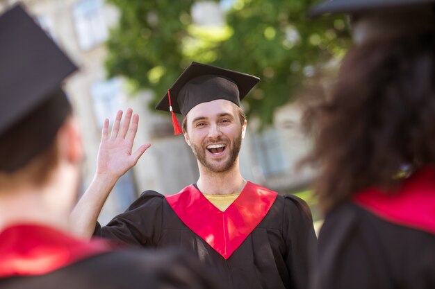 Día feliz. Graduados de universidades sintiéndose felices y sonriendo amablemente