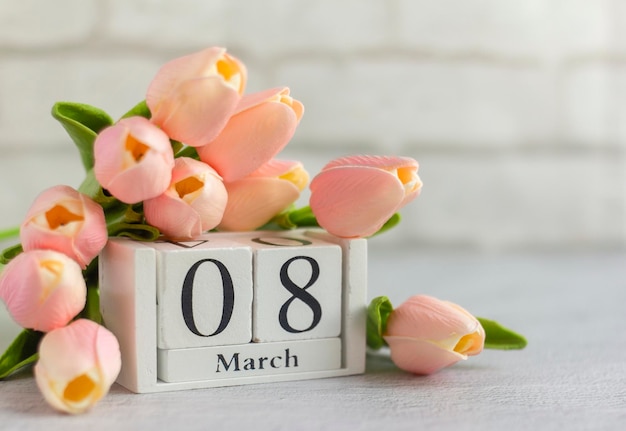 Dia Internacional da Mulher. 8 de março em um calendário de madeira decorado com flores.