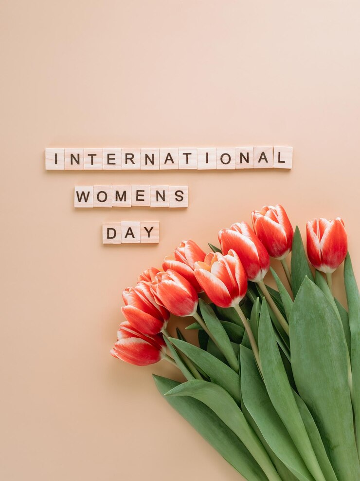Foto dia internacional da mulher ou conceito de oito de março com espaço de cópia texto do dia mundial da mulher e um feixe de tulipas vermelhas em fundo de champanhe bege vista superior ou plana vertical