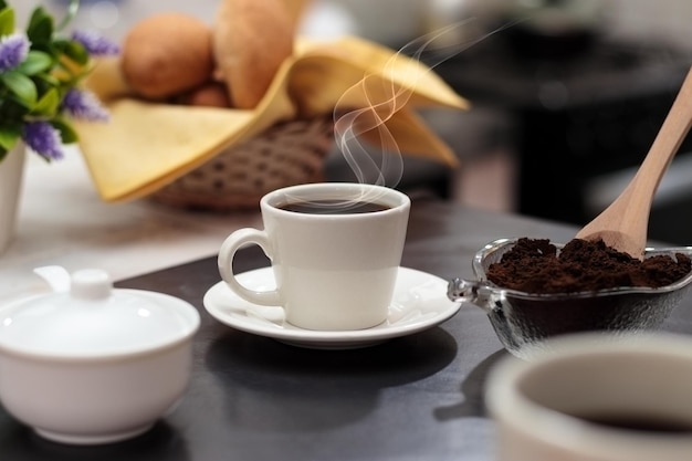 Dia internacional do café tradicional bebida colombiana conceito de café da manhã xícara de café açucareiro e pão na cozinha closeup