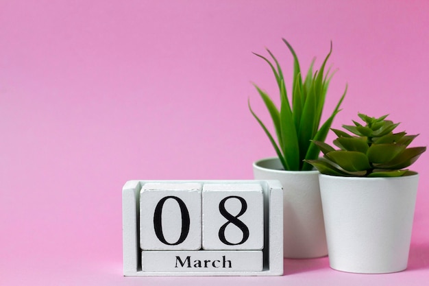 Día Internacional de la Mujer 8 de marzo en un calendario de madera sobre un fondo rosa
