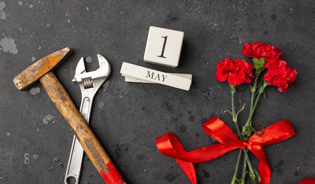 Día Internacional de la Solidaridad de los Trabajadores 1 de mayo concepto llave y martillo con flores de clavel