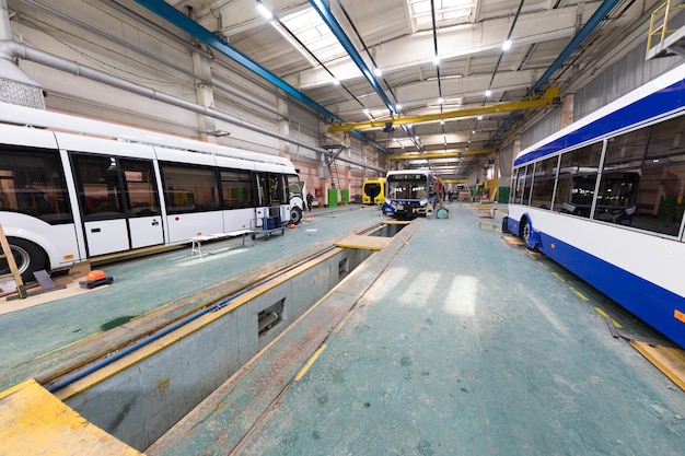 Un día laboral de fabricación de autobuses automáticos modernos con trabajadores de automóviles sin terminar con uniforme de protección