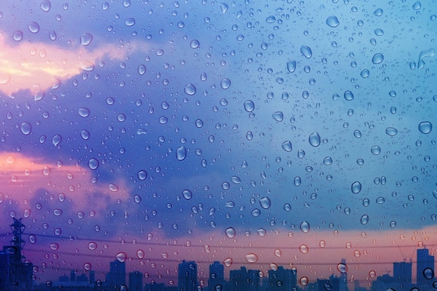 Día lluvioso en la ciudad durante el crepúsculo. centrado en Droplet. Fondo de textura de agua, gotas de lluvia sobre la ventana de cristal