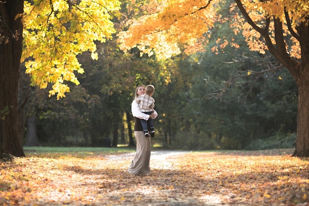 El día de la madre el amor de la familia la familia en el otoño caminar en la naturaleza al aire libre madre e hijo con ternura de abrazo