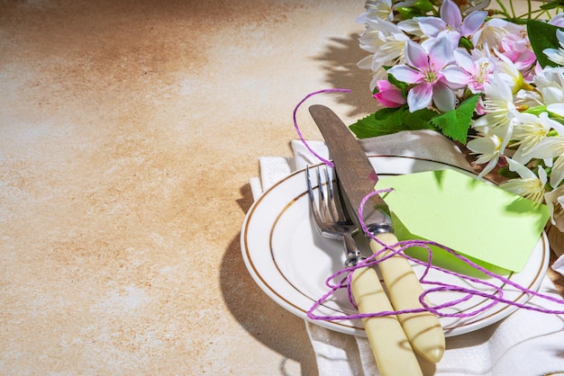 Día de la madre boda cumpleaños primavera vacaciones tarjeta de felicitación fondo Día de la madre ajuste de la mesa flatlay con plato tenedor cuchillo flores de primavera caja de regalo presente con cinta vista superior espacio de copia