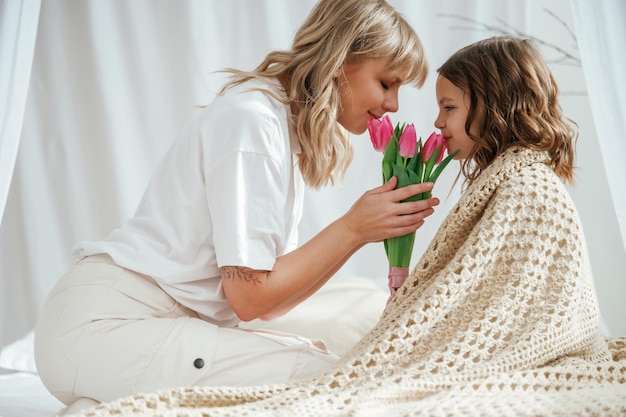 Día de la Madre con la hija y las flores en casa juntos