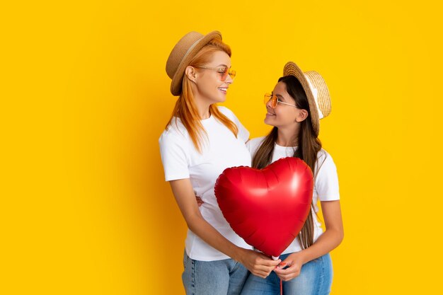 Día de la madre Madre e hija sonrientes aisladas sobre fondo amarillo Personas de la fiesta de cumpleaños