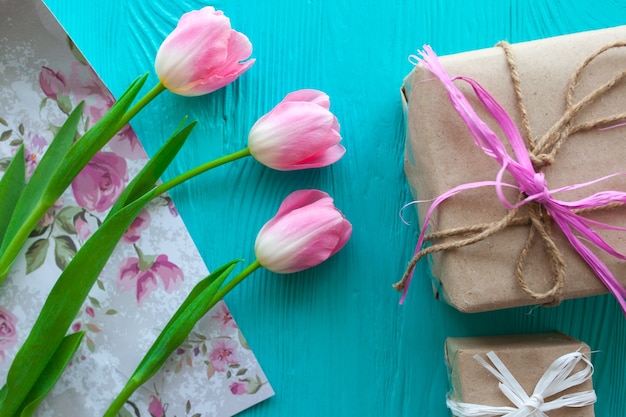 Día de la Madre. Tulipanes rosa y presenta sobre fondo azul