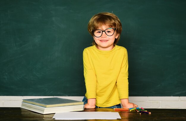 Foto día de los maestros niño escolar o preescolar aprende el concepto de educación científica niño sonriente y alegre en la pizarra