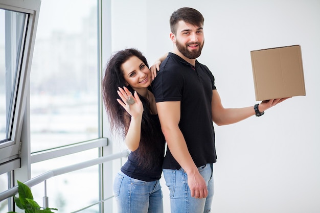 Día de la mudanza. Feliz pareja joven llevando cajas.