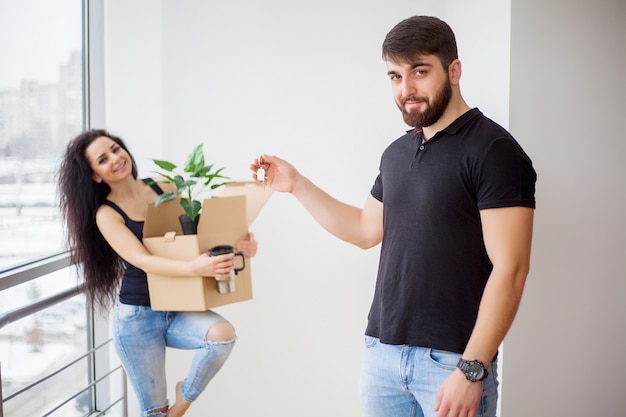 Día de la mudanza. Feliz pareja joven llevando cajas