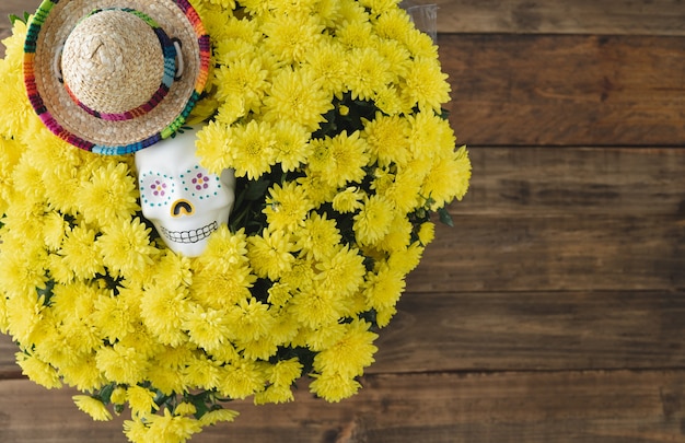 Dia de los Muertos. Cráneo y flores amarillas sobre fondo de madera. Copie el espacio.