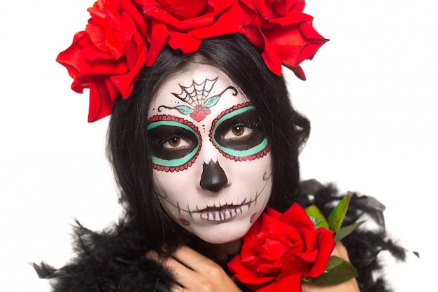 Dia de los Muertos. Festividad de Todos los Santos. Mujer joven en el día de los muertos máscara cráneo cara arte y rosa. Aislado en blanco de cerca.