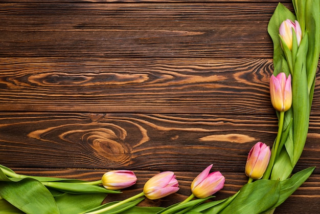 Dia de la mujer. Ramo de tulipanes rosa sobre fondo de tablas de madera, espacio de copia, vista superior
