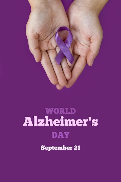 Dia Mundial do Alzheimer. 21 de setembro. Dia Internacional da Epilepsia. Mãos adultas segurando uma fita roxa sobre fundo roxo. Dia Mundial do Lúpus. Foto verticalmente.