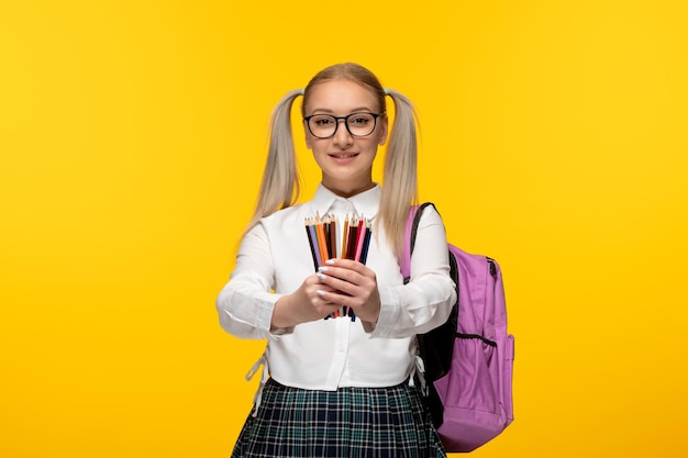 Dia mundial do livro sorridente estudante de uniforme com mochila rosa e lápis coloridos