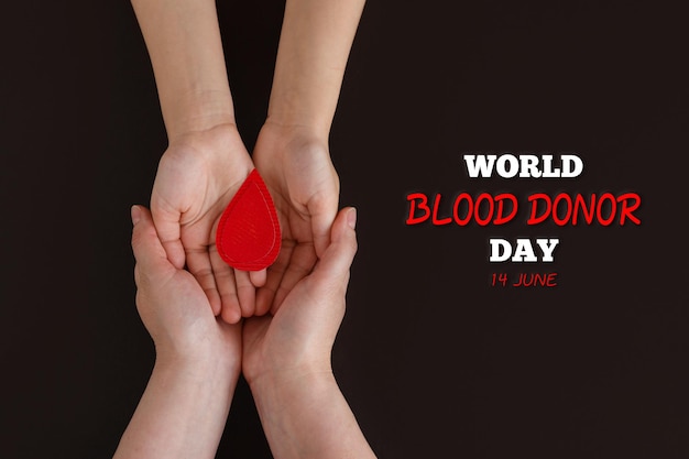 Día mundial del donante de sangre Mamá y bebé sosteniendo una gota de sangre sobre fondo negro Día mundial de la hemofilia