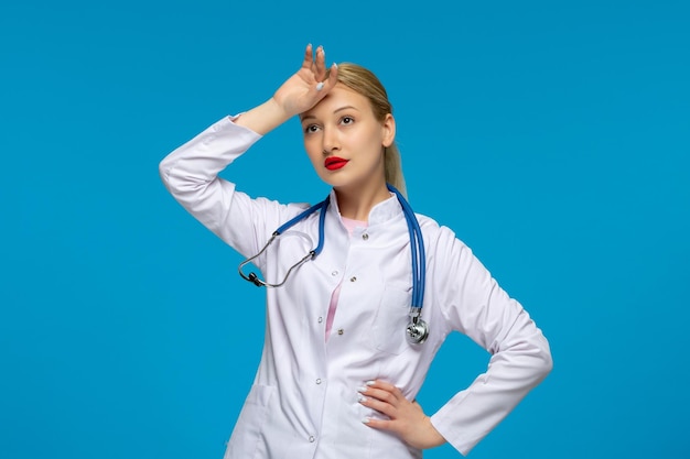 Día mundial del médico médico cansado tocando la frente con el estetoscopio en el abrigo médico