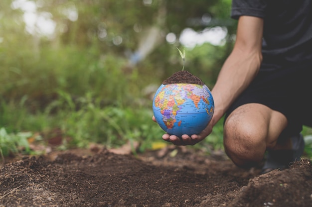 Foto día mundial del medio ambiente. amar al mundo. mano sosteniendo un globo terráqueo