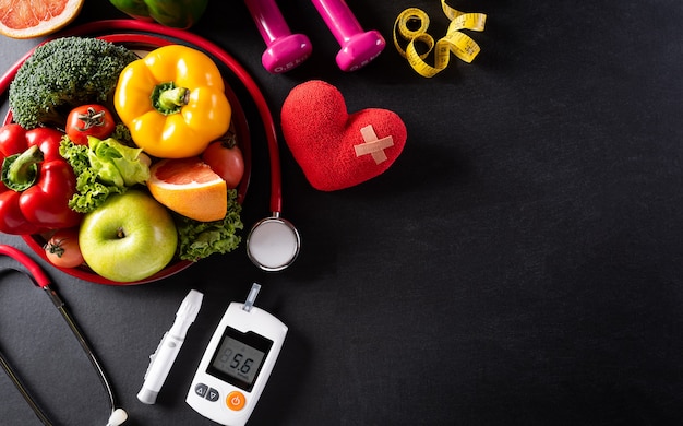 Día mundial de la salud y concepto médico. Vista superior de comida sana en plato con estetoscopio