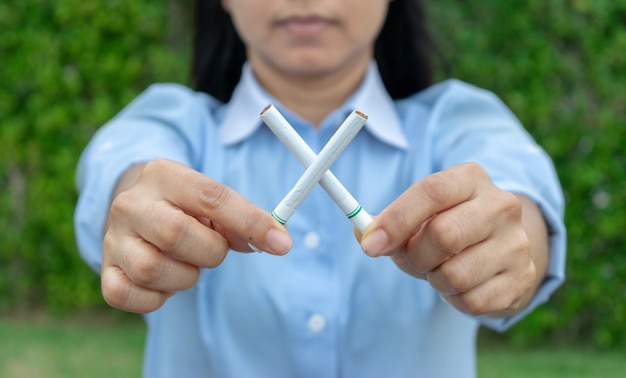 Dia mundial sem tabaco. pare de fumar. feche acima da mão da mulher que guardara cigarros cruzados.