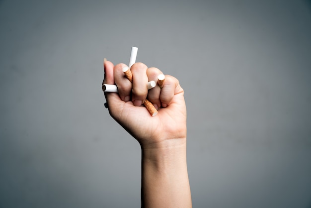 Día Mundial Sin Tabaco, 31 de mayo. DETENER fumar. Hombre mano aplastando cigarrillos