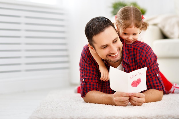 Día del padre Familia feliz hija dando a papá tarjeta de felicitación