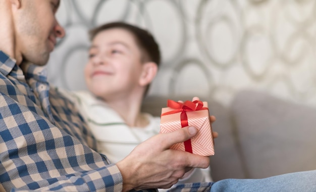 Día del padre Hijo feliz felicitando a papá y dando regalos en casa