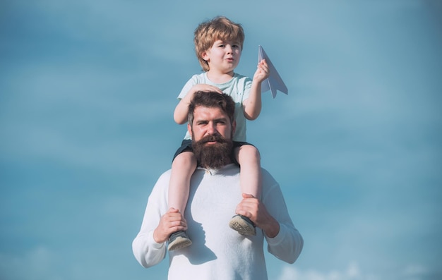 Día del padre padre dando hijo paseo en la espalda en el parque familia feliz y pequeño hijo jugando en verano azul