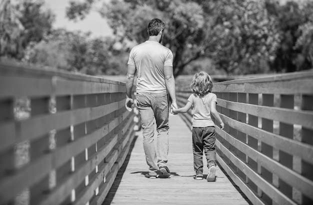 Día del padre padre e hijo caminando al aire libre vista posterior valor familiar infancia y paternidad