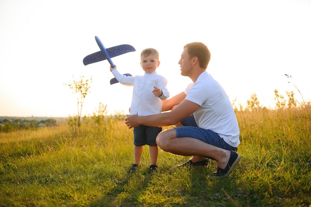 Día del padre papá e hijo jugando juntos al aire libre avión