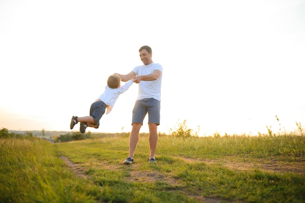 Día del padre Papá e hijo jugando juntos al aire libre en un verano Familia feliz padre hijo al atardecer