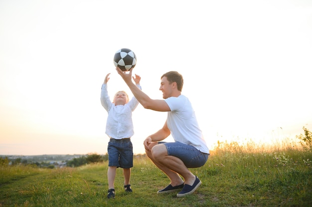 Foto día del padre papá e hijo jugando juntos al aire libre en un verano familia feliz padre hijo al atardecer