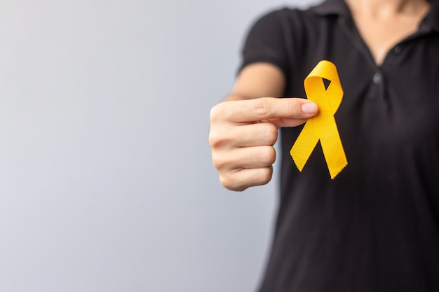 Día de prevención del suicidio Sarcoma infantil Mes de concientización sobre el cáncer de vejiga y huesos Cinta amarilla para apoyar a las personas en la vida y la enfermedad de los niños Concepto de atención médica y día mundial contra el cáncer